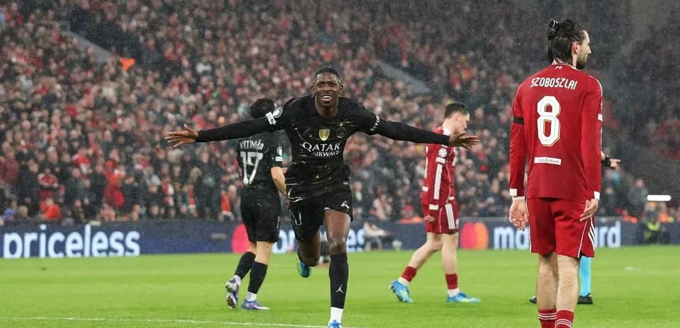 Joueur célébrant un but sous la pluie à Anfield
