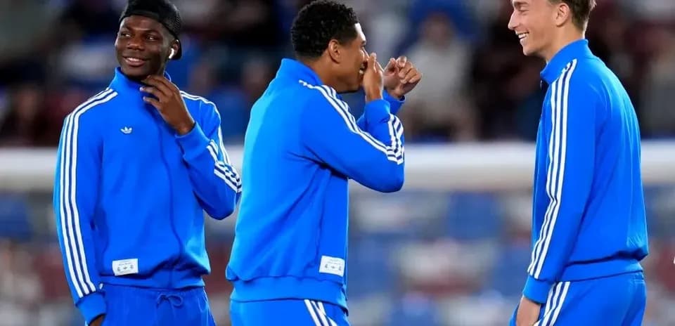 Trois joueurs en survêtement discutant sur le terrain