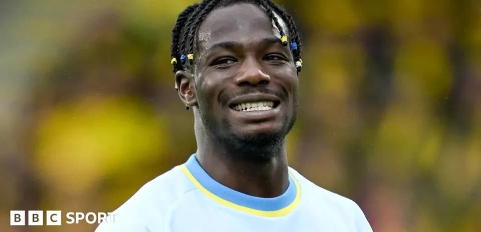 Joueur souriant en maillot de football sur le terrain