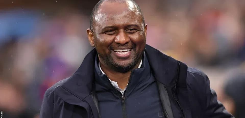 Entraîneur souriant sur le terrain pendant un match