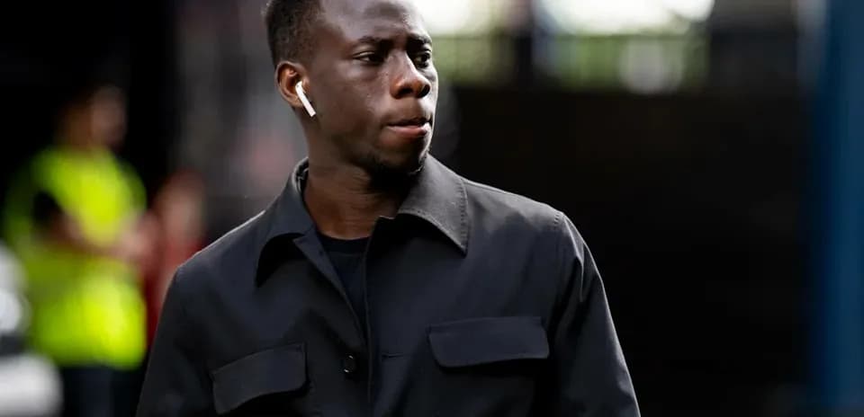 Joueur marchant avec des écouteurs dans une tenue noire