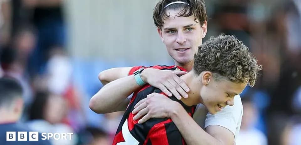 Deux joueurs s'enlaçant sur le terrain de football