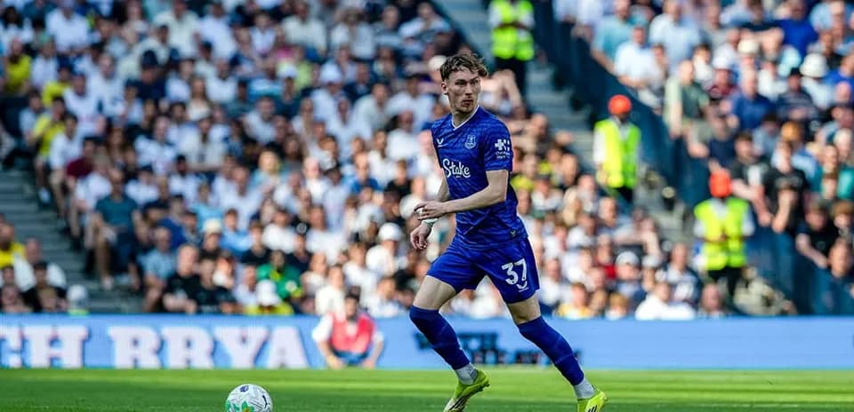 Joueur en bleu courant avec le ballon sur le terrain