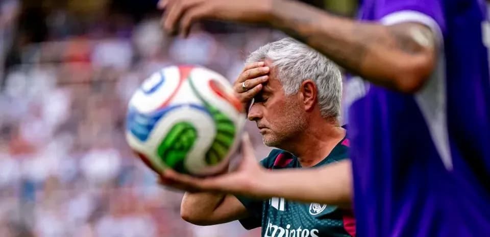 Entraîneur touchant son front avec un ballon en arrière-plan