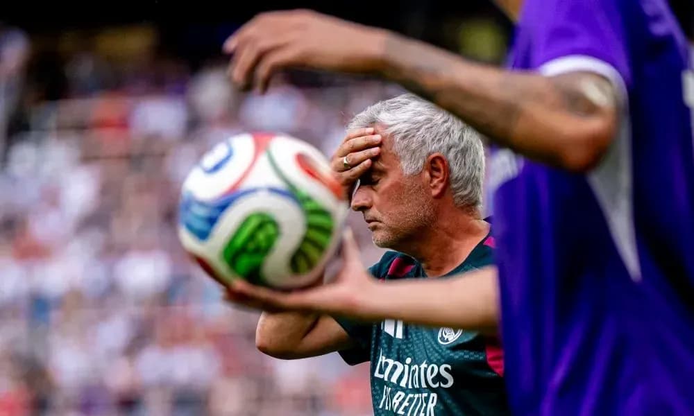 Entraîneur touchant son front avec un ballon en arrière-plan