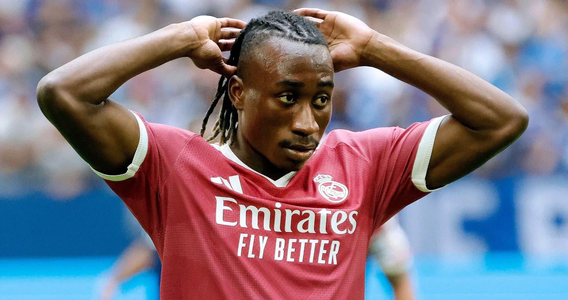 Joueur de football en maillot rose avec les mains sur la tête