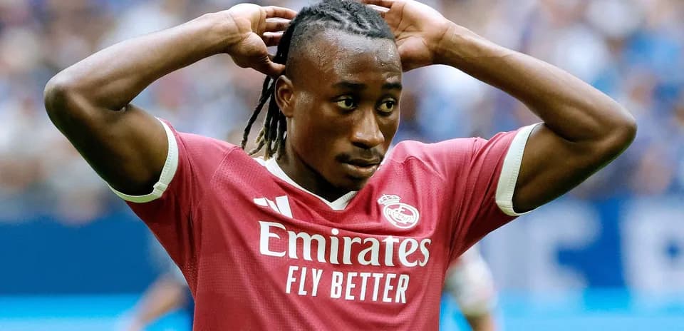 Joueur de football en maillot rose avec les mains sur la tête