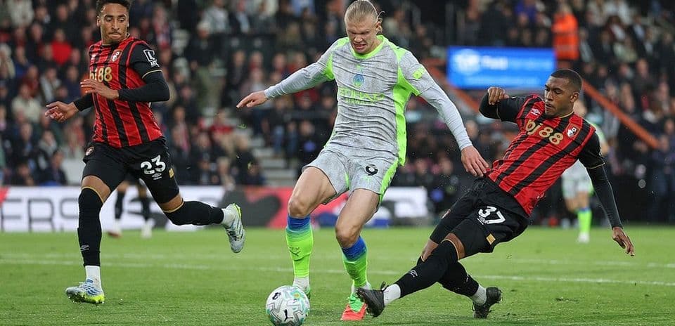 Haaland dribbles entre deux défenseurs de Bournemouth