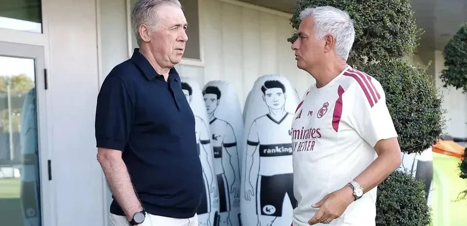 Deux entraîneurs discutant près du terrain d'entraînement