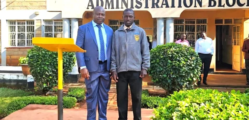 Deux hommes posant devant le bloc administratif d'une école