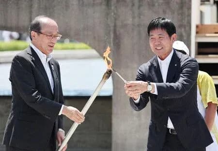 Deux hommes allumant la flamme olympique ensemble