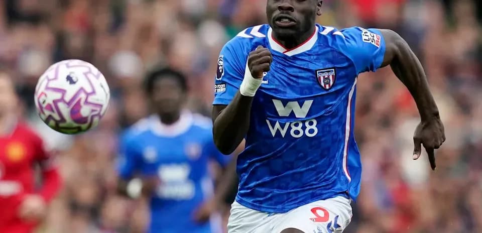 Joueur en maillot bleu courant avec le ballon