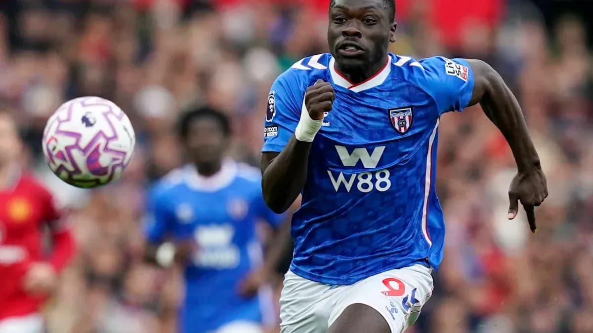 Joueur en maillot bleu courant avec le ballon