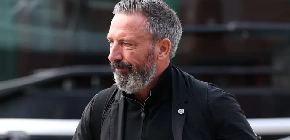 Homme avec barbe grise marchant près d'un bus