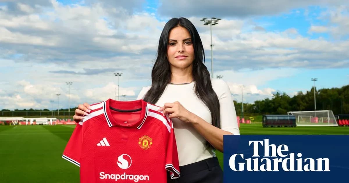 Femme tenant un maillot de Manchester United sur terrain