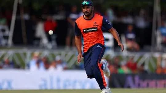 Joueur de cricket courant après la balle sur le terrain