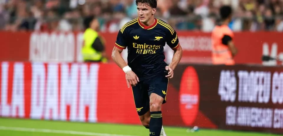 Joueur d'Arsenal dribblant avec le ballon sur le terrain