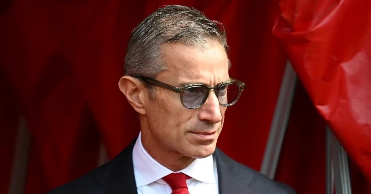Homme en costume avec lunettes près d'un rideau rouge