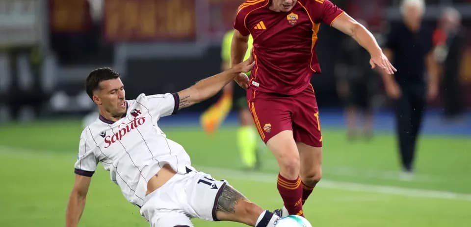 Joueurs de Bologna et AS Roma en action