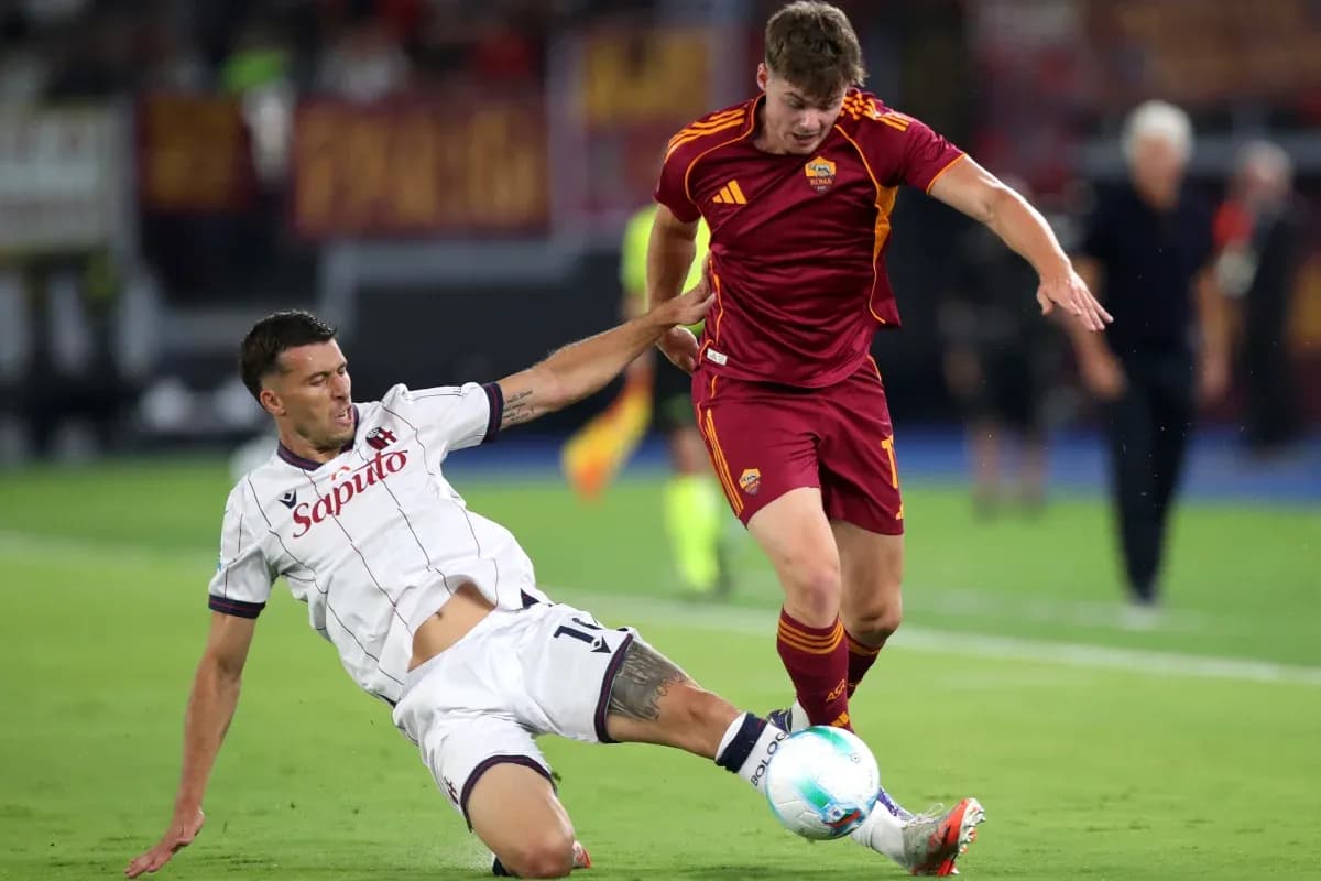 Joueurs de Bologna et AS Roma en action