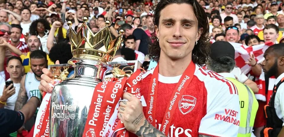 Joueur tenant le trophée de la Premier League avec supporters