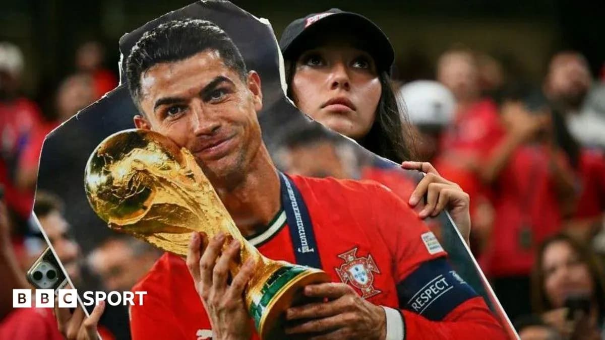 Supporter holding cutout of Cristiano Ronaldo with trophy