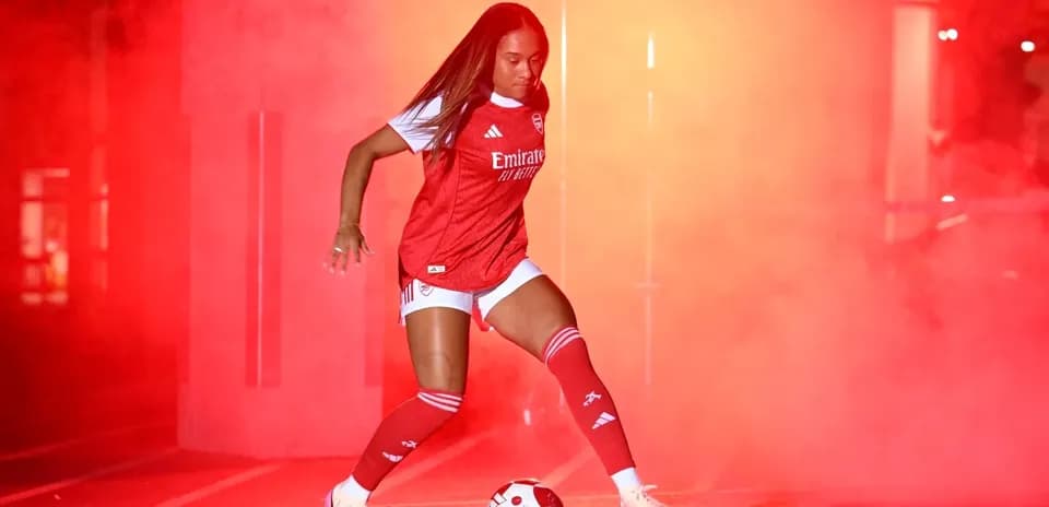 Joueuse d'Arsenal dribblant un ballon dans la fumée