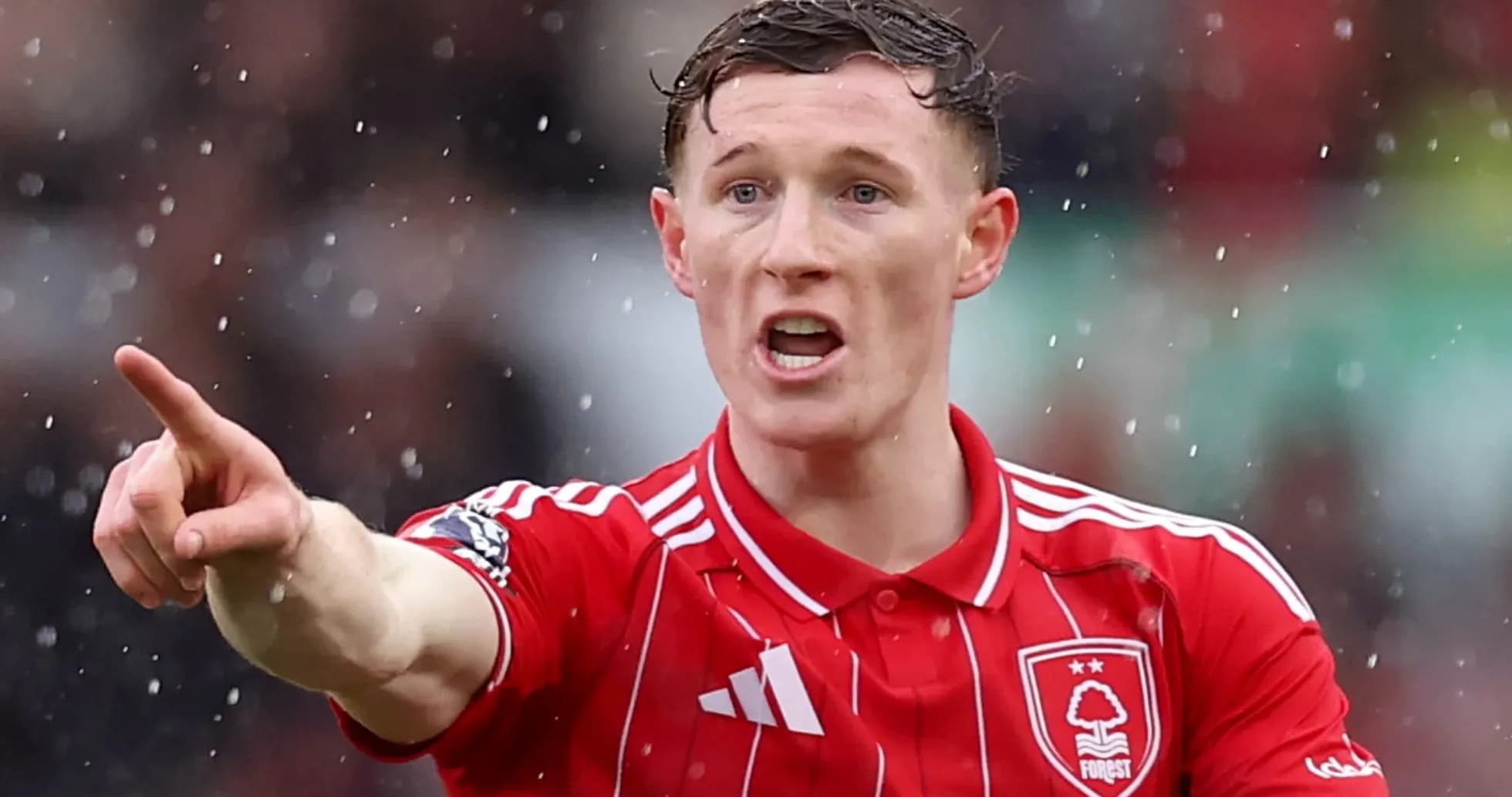Joueur de football pointant pendant un match sous la pluie