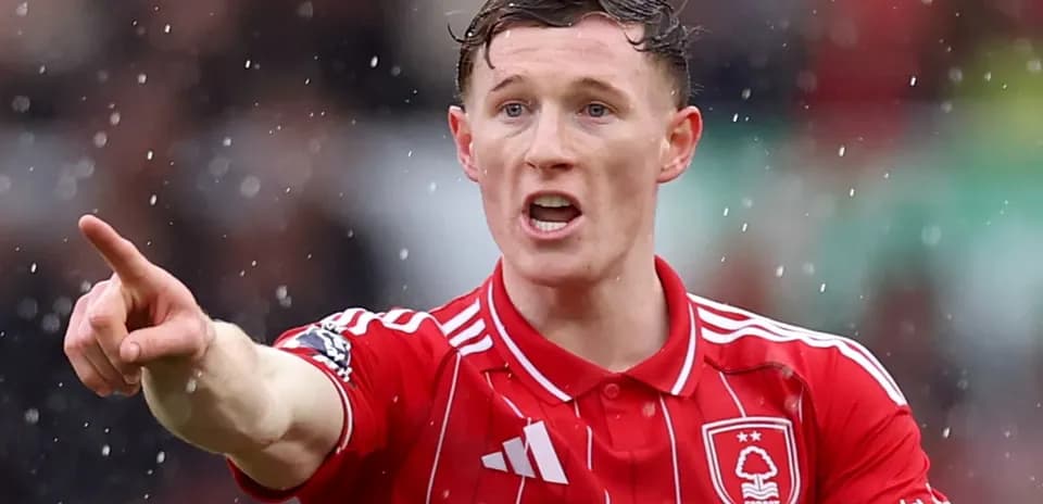 Joueur de football pointant pendant un match sous la pluie