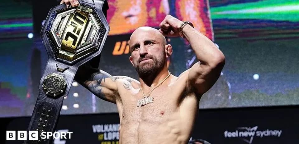 Fighter celebrating with UFC championship belt raised