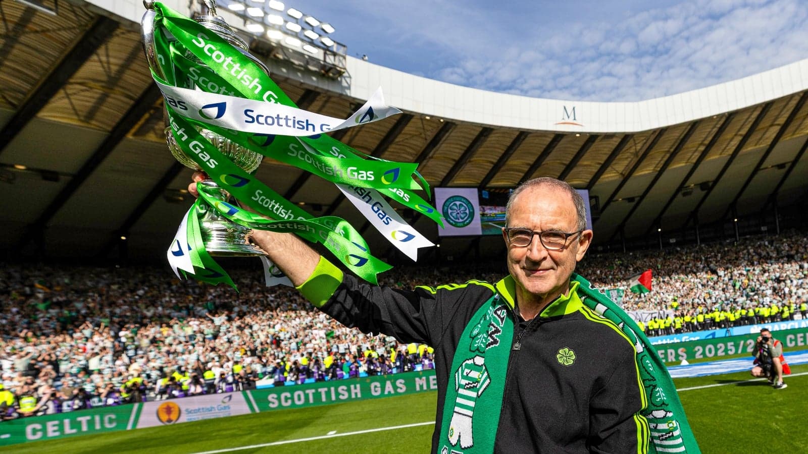 Homme levant un trophée avec des rubans verts