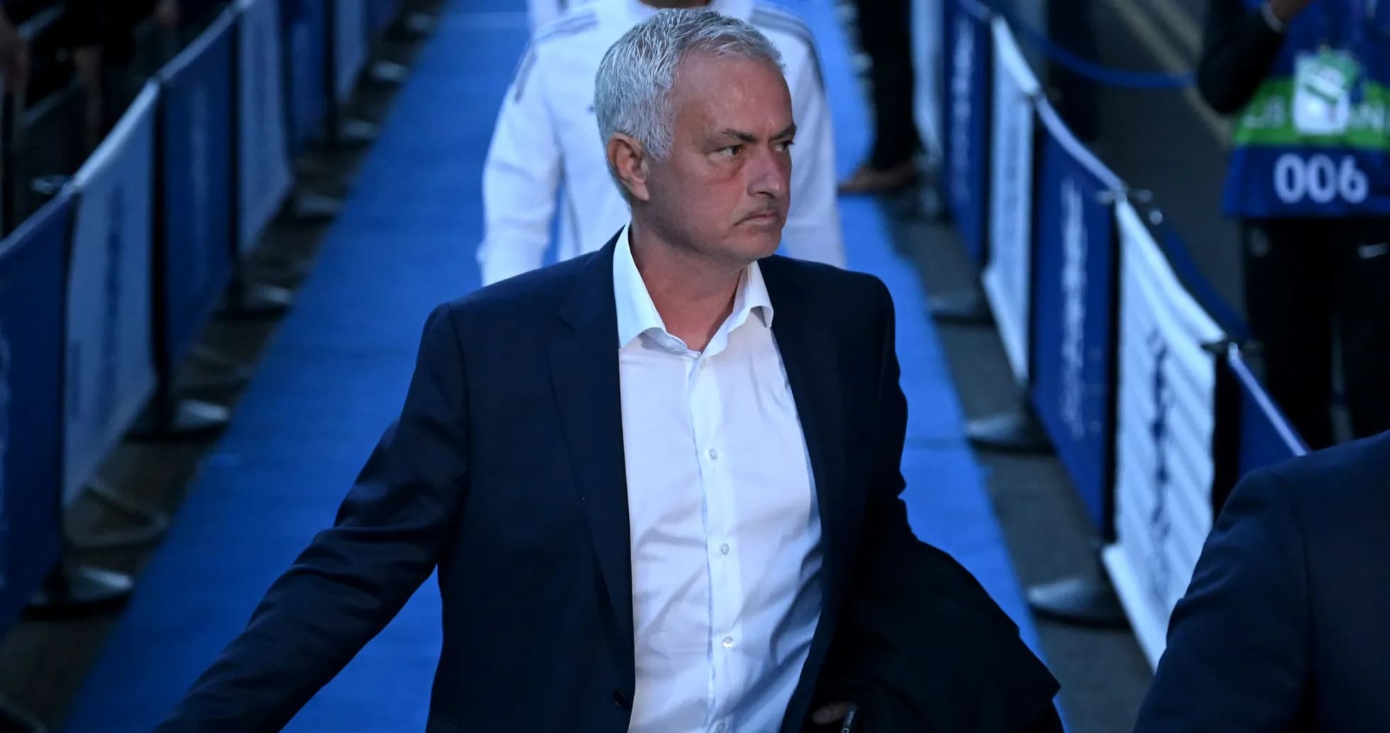 Entraîneur marchant sur le tapis bleu avant le match