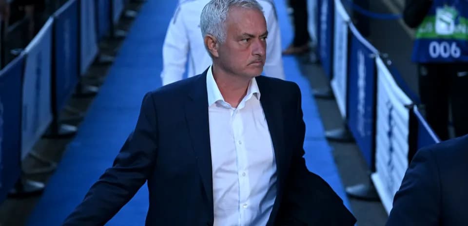 Entraîneur marchant sur le tapis bleu avant le match