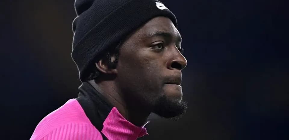 Joueur en tenue rose avec bonnet noir sur le terrain
