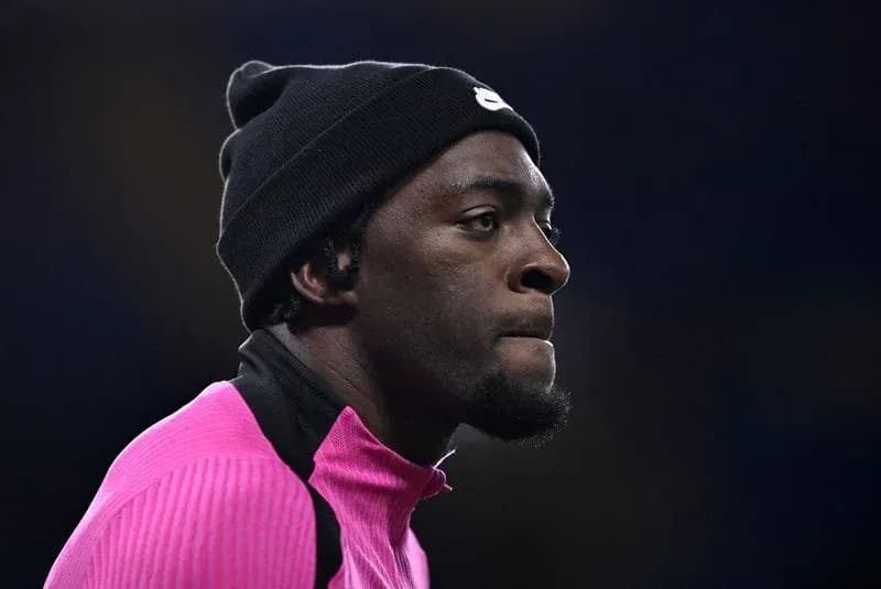 Joueur en tenue rose avec bonnet noir sur le terrain