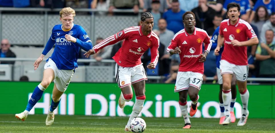 Joueur de Manchester United poursuivant un joueur d'Everton