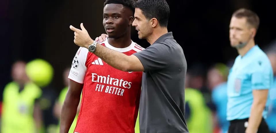 Mikel Arteta discutant avec Bukayo Saka pendant un match