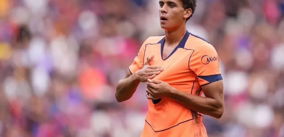 Joueur en tenue orange sur le terrain de football