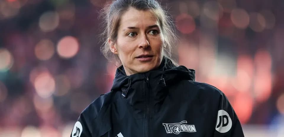 Femme en veste noire sur le terrain de football