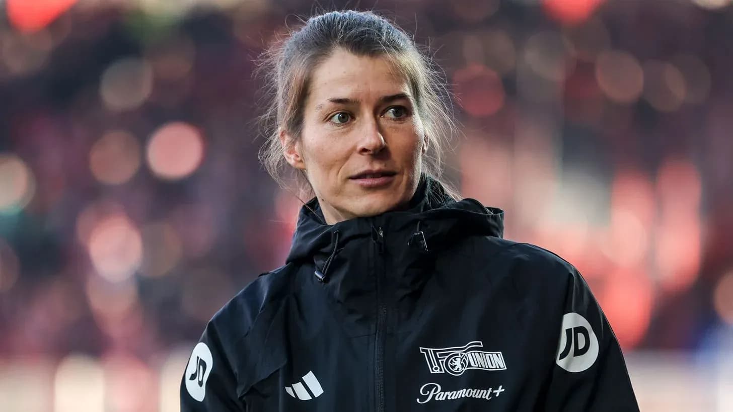 Femme en veste noire sur le terrain de football