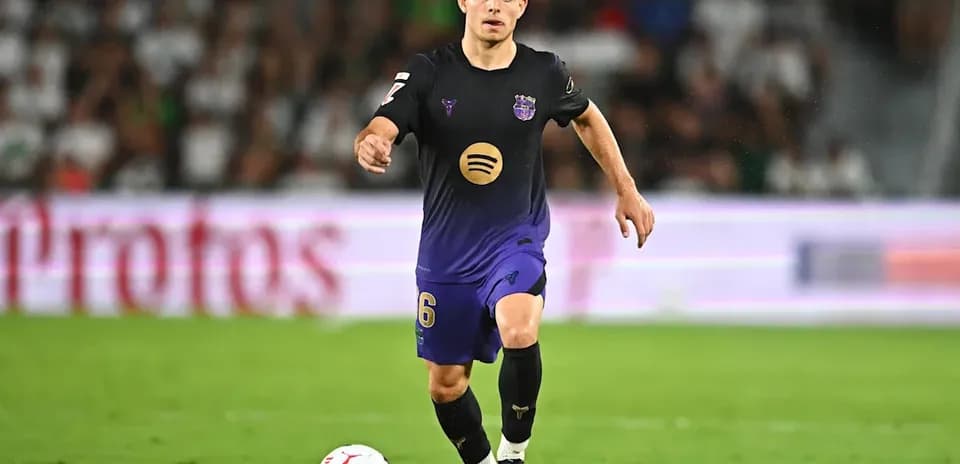 Joueur en uniforme dribblant le ballon sur le terrain