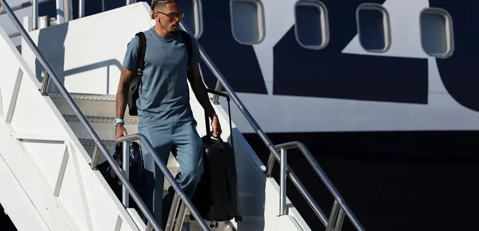 Joueur descendant de l'avion avec une valise