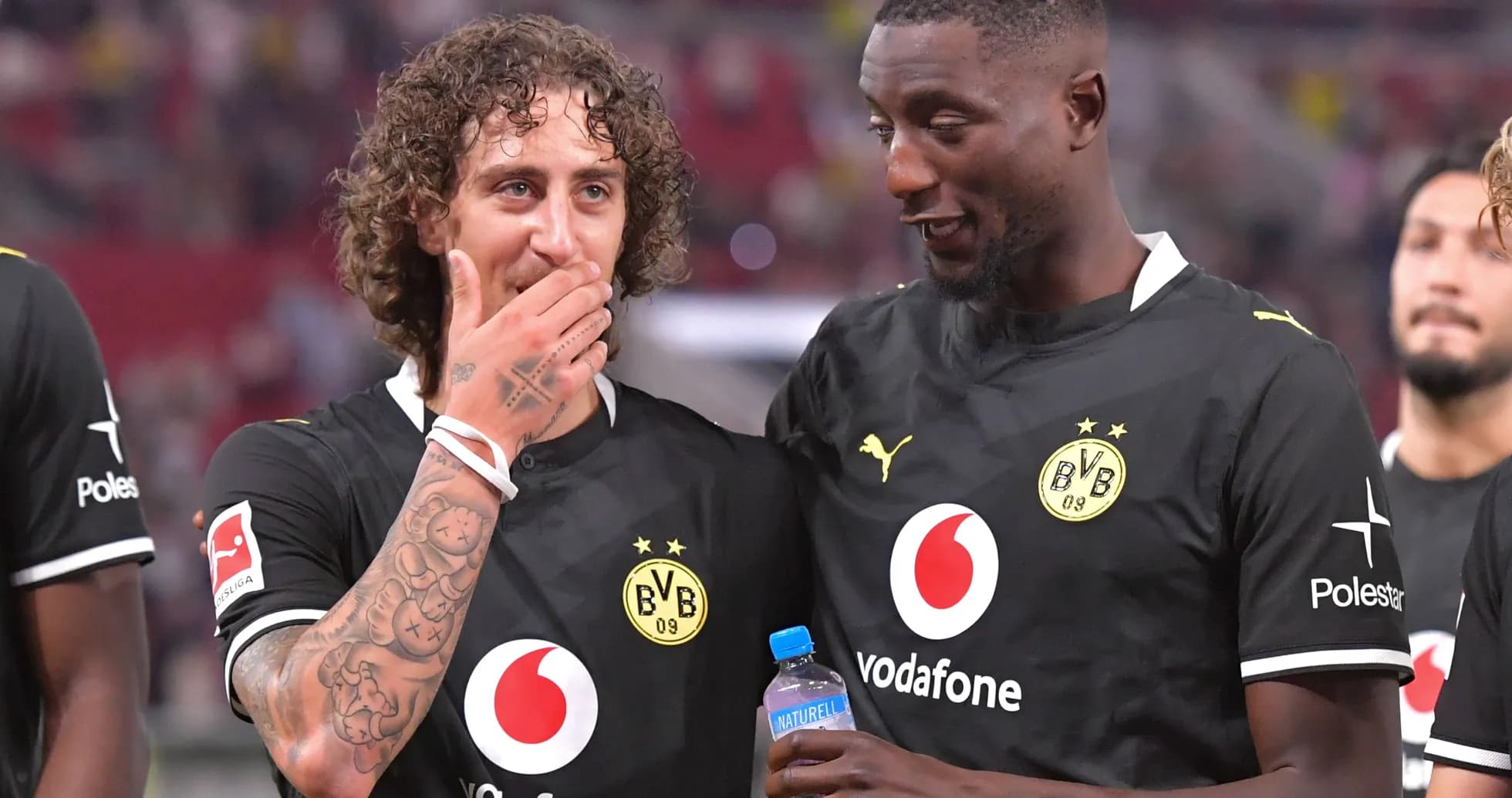 Joueurs de Borussia Dortmund discutant sur le terrain