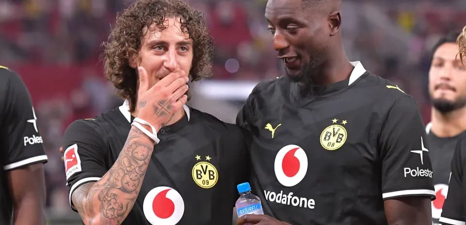 Joueurs de Borussia Dortmund discutant sur le terrain