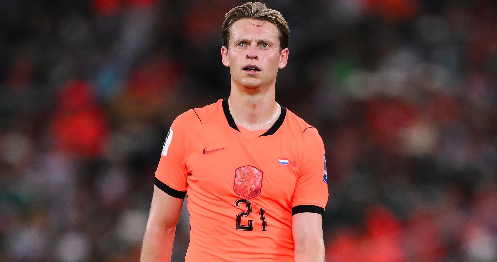 Joueur en maillot orange sur le terrain de football