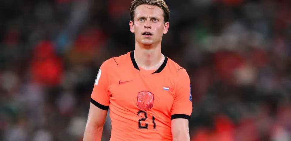 Joueur en maillot orange sur le terrain de football