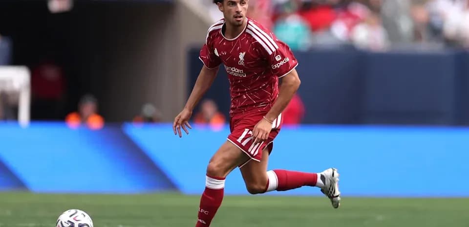 Joueur de Liverpool dribblant le ballon sur le terrain