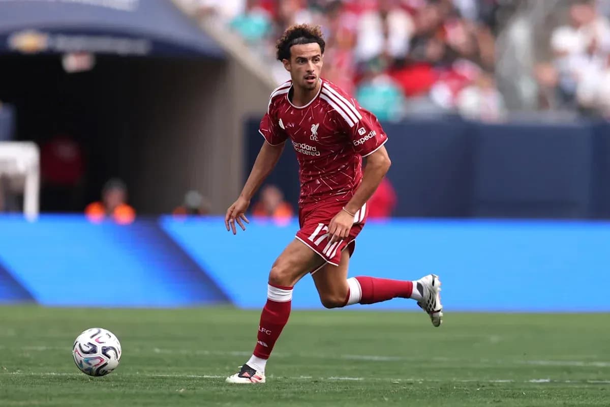 Joueur de Liverpool dribblant le ballon sur le terrain