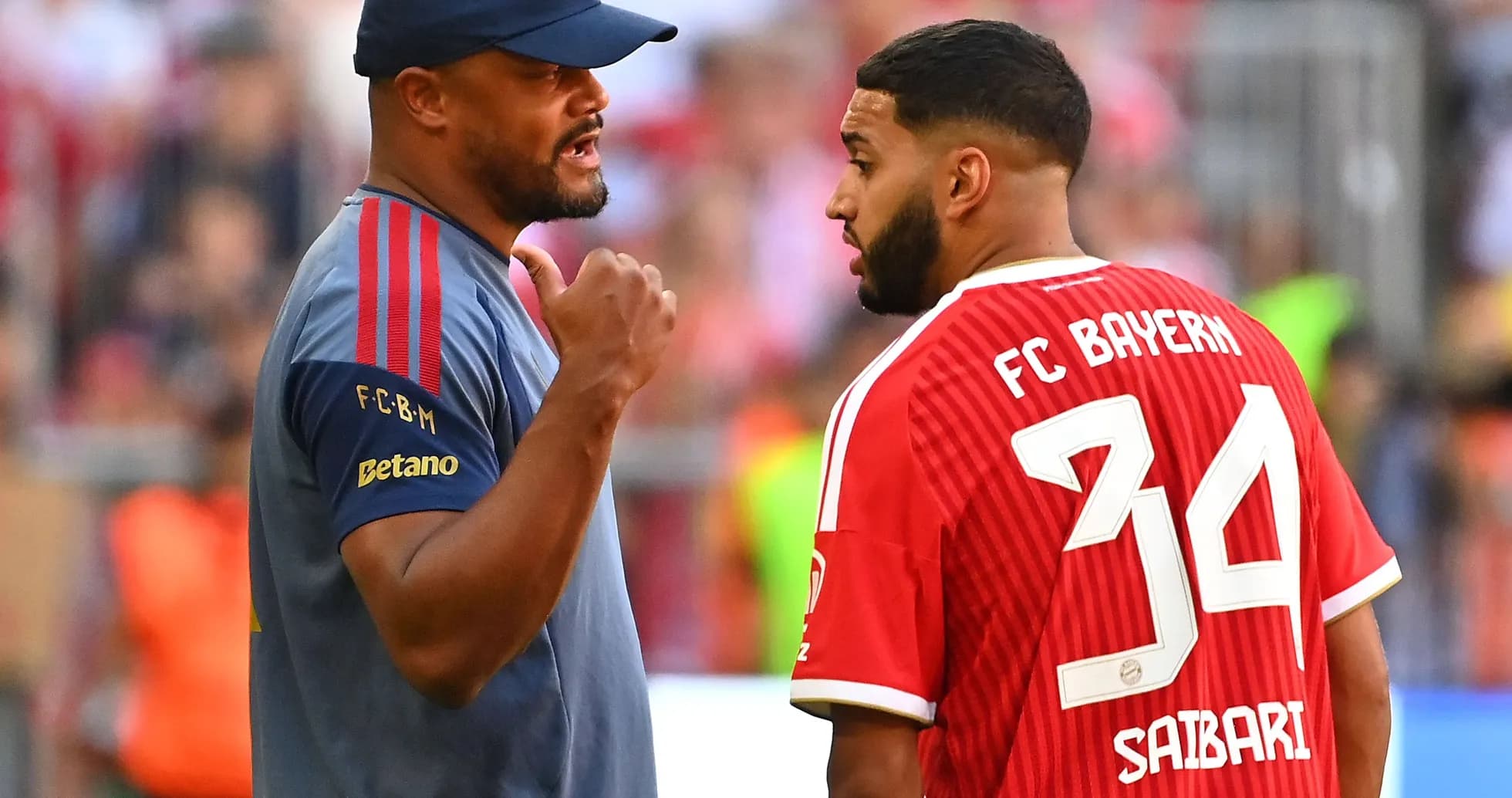 Entraîneur discutant avec joueur de FC Bayern