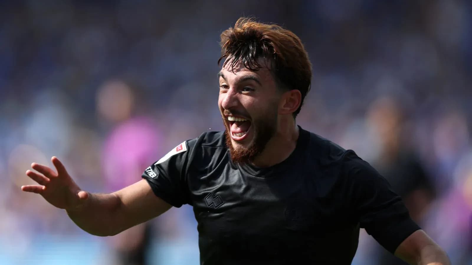 Joueur célébrant un but avec enthousiasme sur le terrain